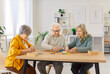 © Studio Romantic - Group of elderly people sitting at wooden table, solving colorful puzzles together in nursing home. Seniors focusing on assembling pieces, engaging in fun cognitive activity for memory stimulation.