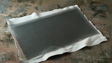 Aufkleber - A simple scene with a piece of white paper placed on a table, possibly used as a prop for note-taking or writing