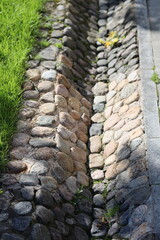 Aufkleber - A stone wall with lush green grass growing on top, ideal for use in architectural or landscape design contexts