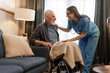 © Maria Vitkovska - Smiling, beautiful nurse covering elderly man in wheelchair with blanket at home