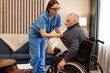 © Maria Vitkovska - Beautiful nurse assisting elderly man in wheelchair at home