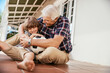 © Marko Geber - Portrait of a grandfather and grandson sitting together with a soccer ball on a balcony of a house