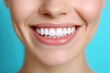 © Oleksandr - Woman smiles brightly showing perfect teeth and gums against blue background