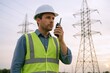 © Generative AI - Male utility worker wearing safety vest and helmet monitoring power lines outdoors.