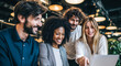 © designermetin - Diverse Business Team Collaborating In Office Environment Smiling And Engaging Around Open Laptop