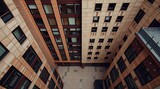 A high-angle perspective high-resolution stock photo of a commercial office building, looking down from an elevated viewpoint, in natural earth tones, browns, and beiges with muted colors