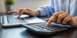© arthub Tokyo - Hands type on a laptop and use a calculator for finance planning and accounting, illustrating business and technology integration.