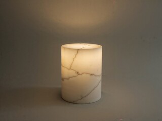 Poster - Elegant Illumination, A Cream-Colored Marble-Topped Cylinder Pedestal Radiating Soft Light with Intricate Veining Details