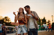 © Drazen - Happy couple of festival goers eating after open air music concert in summer.