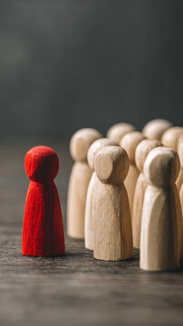 Red figure stands out from wooden group wooden figures standing out