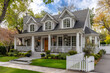 © Tymofii Borysenko - Beautiful two-story house with charming architecture located in a peaceful neighborhood, featuring a welcoming porch, manicured lawn, and white picket fence in autumn light
