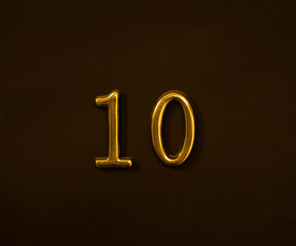 yellow gold golden  ten 10 Number Write isolated On black Dark Wall door Background. white 10 Number Logo.