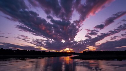Wall Mural - beautifully filmed 4k time lapse of sunset or sunrise skies with dramatic clouds over a tranquil river ideal for conveying nature’s grandeur and offering travel content with breathtaking visuals