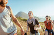 © Marko Geber - Young and diverse group of people and hikers hiking on a ridge overlooking the ocean and a beautiful sunset in South Africa