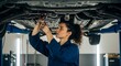 © Gabriel Bayer - Female Car Mechanic Tightening Bolts Under Lifted Vehicle