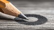 © elmyra - A sharpened pencil point rests in the center of a circle of graphite.