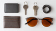 © Zubair - Flat lay of everyday household items including keys, wallet, and sunglasses neatly arranged on a white surface