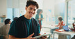 © BuyOutFelix03/peopleimages.com - Tablet, learning and portrait of happy man in university classroom for study or development. Tech, student and person in college for knowledge, scholarship or research project online for education
