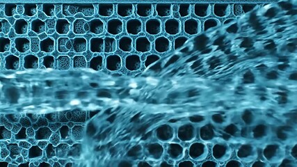 Rushing water pouring through a grid of intricate, rounded holes, cyan colored