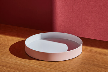 Aufkleber - White round tray with smooth surface and soft shadow sits on wooden table against red wall, creating minimalist and modern atmosphere with clean lines and gentle light