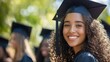 © sambath - A young woman in a graduation cap and gown, smiling, with other graduates in the background.