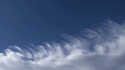 Wall Mural - Beautiful slow motion 4K time lapse showing clear azure skies with delicate white cirrus clouds like feathers drifting gently evoking a peaceful and high altitude atmosphere for weather or