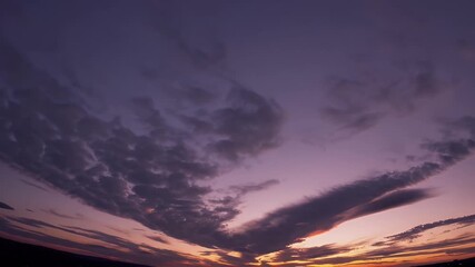 Wall Mural - Mesmerizing 4K timelapse of a sunset sky with vibrant colors blending and shifting as clouds gracefully move and form stunning patterns creating a warm and dynamic natural spectacle against fading