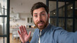 © Yuliia - Glad Caucasian man male father smiling recording video blog speaking camera mobile phone tech at home demonstrating new house happy guy dad discuss vlog household waving hand communication streaming