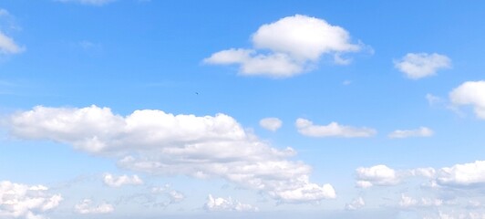 Wall Mural - Bright sky with white fluffy clouds in summer. Blue sky with clouds. Soft white clouds float in the clear blue sky. Clear blue sky, bright spring, wallpaper landscape.