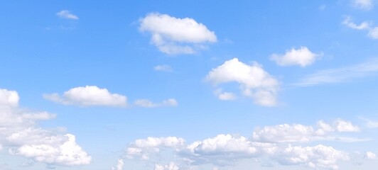 Wall Mural - Bright sky with white fluffy clouds in summer. Blue sky with clouds. Soft white clouds float in the clear blue sky. Clear blue sky, bright spring, wallpaper landscape.
