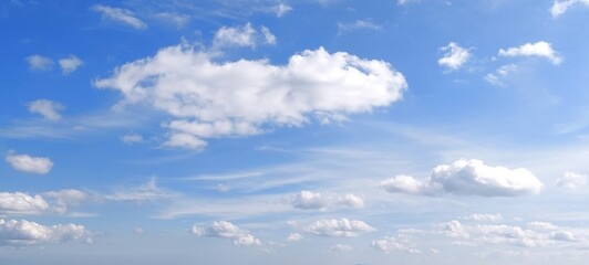 Wall Mural - Bright sky with white fluffy clouds in summer. Blue sky with clouds. Soft white clouds float in the clear blue sky. Clear blue sky, bright spring, wallpaper landscape.
