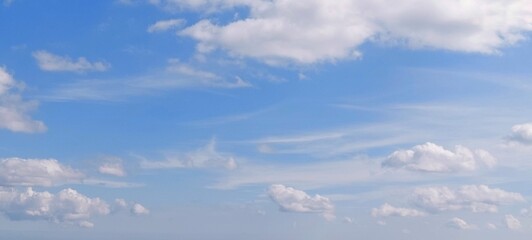Wall Mural - Panoramic cloudscape in clear blue sky in summer. Nature sky background with fluffy clouds.
