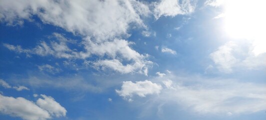 Wall Mural - Panoramic cloudscape in clear blue sky in summer. Nature sky background with fluffy clouds.