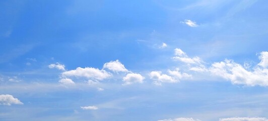 Wall Mural - Panoramic cloudscape in clear blue sky in summer. Nature sky background with fluffy clouds.