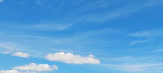 Wall Mural - Panoramic cloudscape in clear blue sky in summer. Nature sky background with fluffy clouds.