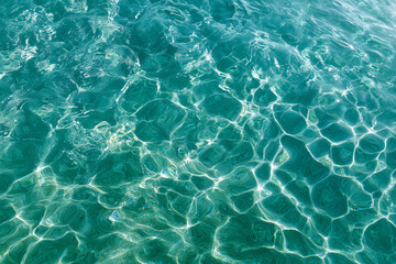 Poster - Clear, turquoise water with rippling patterns. The sunlight dances across the surface, creating beautiful reflections. A close-up shot emphasizes the clarity and purity of the water