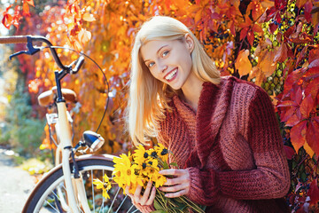 Wall Mural - Autumn girl in good mood posing outdoor. Dreamy girl. Beauty model, young beautiful woman hold autumn leaves. Romantic woman in autumn park. Autumn fall concept.