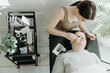 © Nataliya - Portrait of a girl cosmetologist extending eyelashes to a woman.