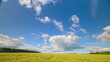 © beholdereye - A beautiful sunny landscape featuring a clear blue sky dotted with fluffy white clouds