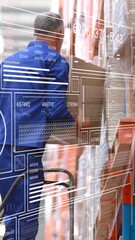 Poster - Warehouse worker moving boxes with animation overlay on transparent screen