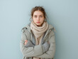 © KingBudi399 - Shivering young woman in winter clothing with soft pastel background, half-body emotional portrait, minimal hand exposure, cold weather discomfort
