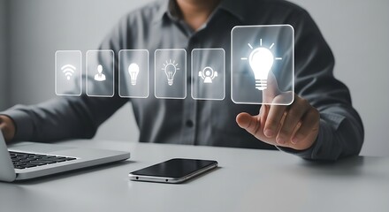 Poster - Person interacting with idea lightbulb icons on a screen with laptop and phone on a white desk