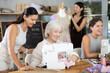 © JackF - In creative course for adults, enthusiastic mature woman working at sewing machine while other participant friendly chatting, collaborating, fitting garment and preparing fabric..