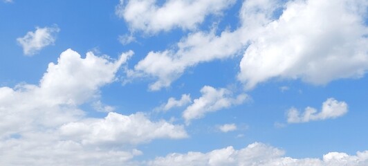 Wall Mural - Panoramic cloudscape in clear blue sky in summer. Nature sky background with fluffy clouds.