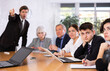 © JackF - Frustrated young guy sitting with group of coworkers at table in director office on blurred background of irritated boss scolding subordinates, pointing out shortcomings and omissions in work