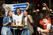 © JackF - Fans with the flag of Uruguay celebrate the victory of their favorite team in a beer bar