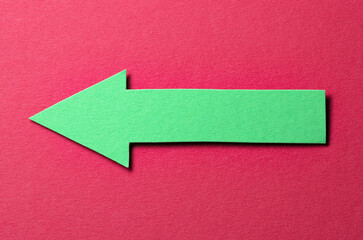 Poster - Green cut out blank paper cardboard arrow direction sign with copy space for text on red background, flat lay top view pointing symbol conceptual message backdrop