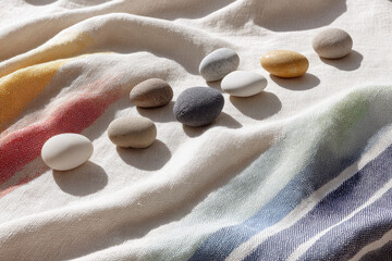 Aufkleber - Minimal composition with evenly spaced soft stones on textured fabric, natural light, neutral and pastel colors, calm and peaceful mood, abstract arrangement, home decor inspiration