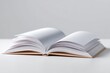 © กาซือมะ สาและ - An open, blank hardcover book lying flat on a white surface, ready for text or graphics. Education, storytelling, knowledge concept.