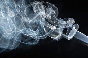 Poster - Wispy trails of smoke gracefully dancing against a stark black backdrop creating an ethereal atmosphere